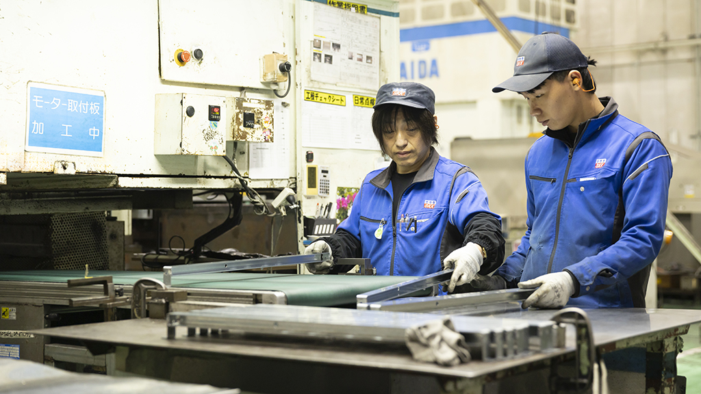 製造設備を操作しながら作業する社員